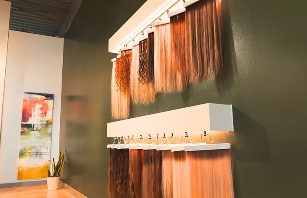 Extension hair in copper, blonde, brunette and curly textures on a display wall