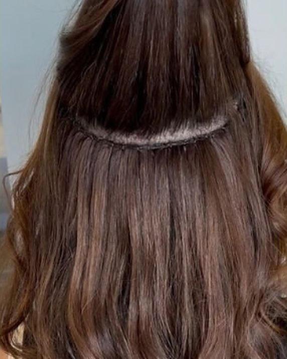Brunette extensions in a clean row, blending into soft waves